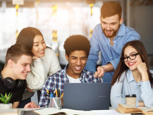 Grupo de jovens estudando ao redor de um notebook, ideal para ilustrar notebook para estudos.