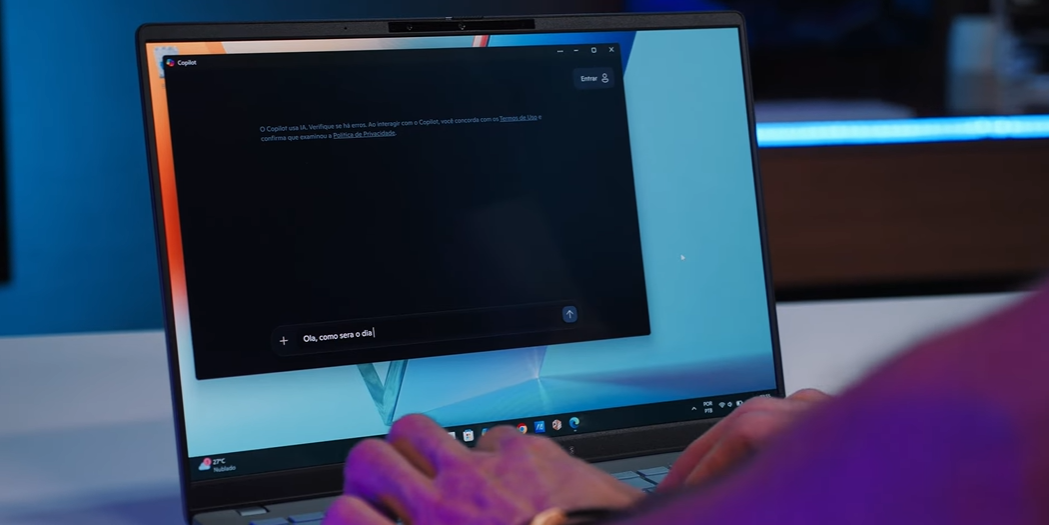  Imagem mostrando o notebook ASUS Vivobook S 14 com a interface do Copilot aberta, enquanto digita uma pergunta em uma caixa de texto.