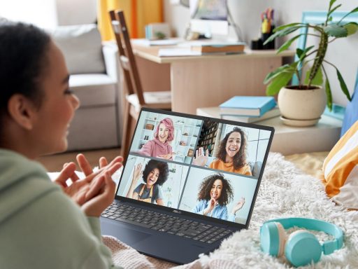 Mulher em chamada de vídeo no notebook ASUS, usando live caption para acessibilidade.