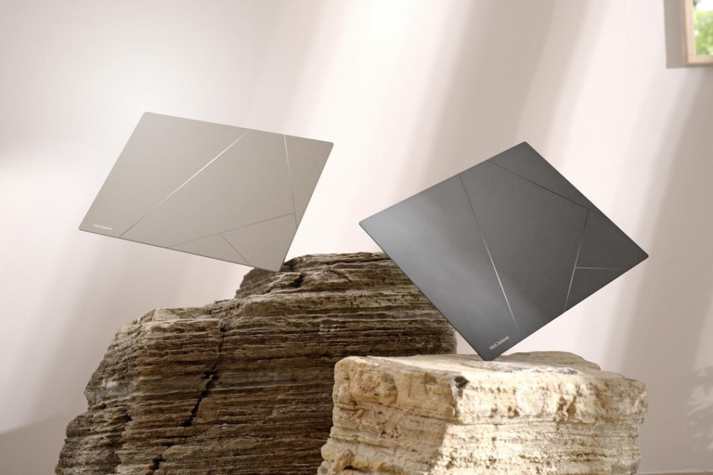Dois notebooks ultrafinos em acabamento sofisticado de ceraluminum, um em tom claro e outro em tom escuro, posicionados sobre rochas.