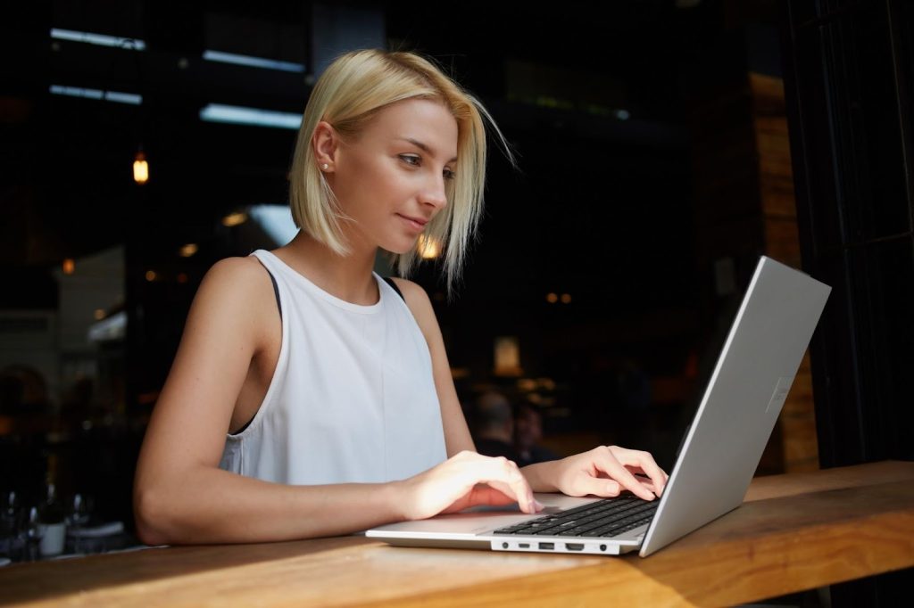 Mulher usando um notebook ASUS, simbolizando a migração do Windows 10 para o Windows 11 devido ao fim do suporte ao Windows 10.