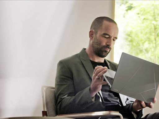 Homem sentado em uma poltrona usando um notebook moderno de acabamento cinza com design geométrico, feito em ceraluminum.