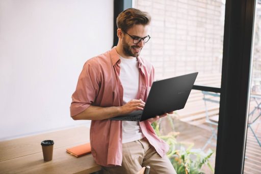 Homem um notebook ASUS, simbolizando a migração do Windows 10 para o Windows 11 após o fim do suporte ao Windows 10.