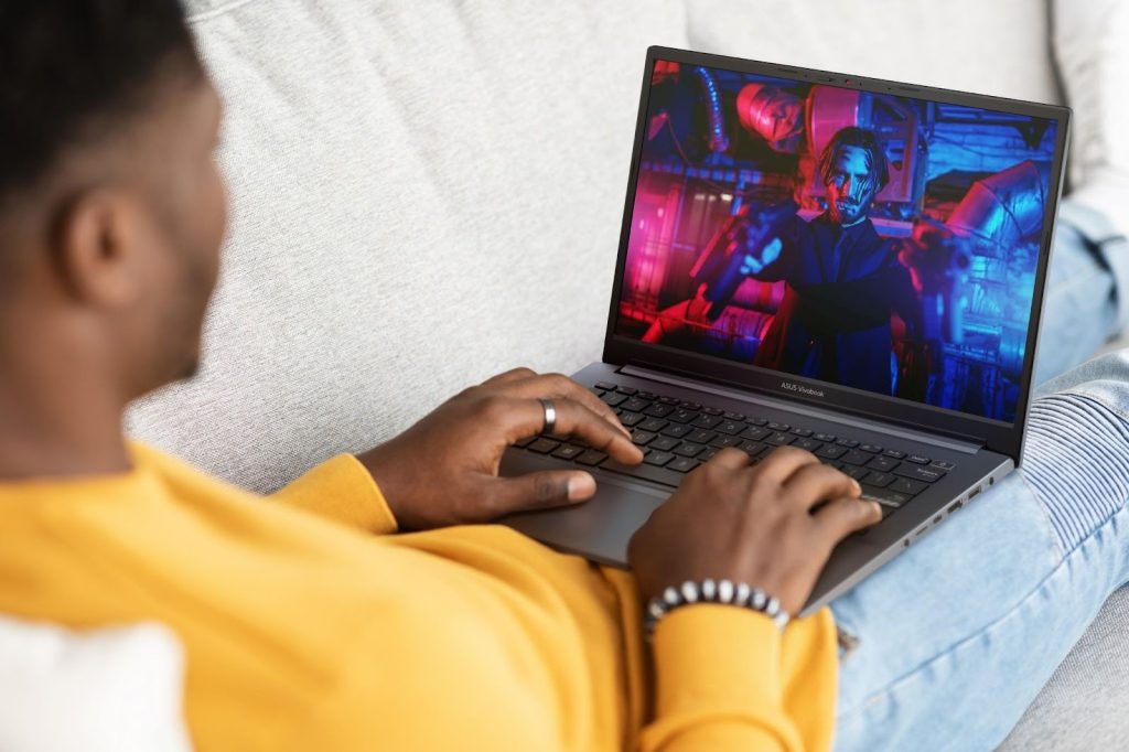 Homem assistindo conteúdo em um notebook, destacando o que é um Vivobook em termos de imersão visual.