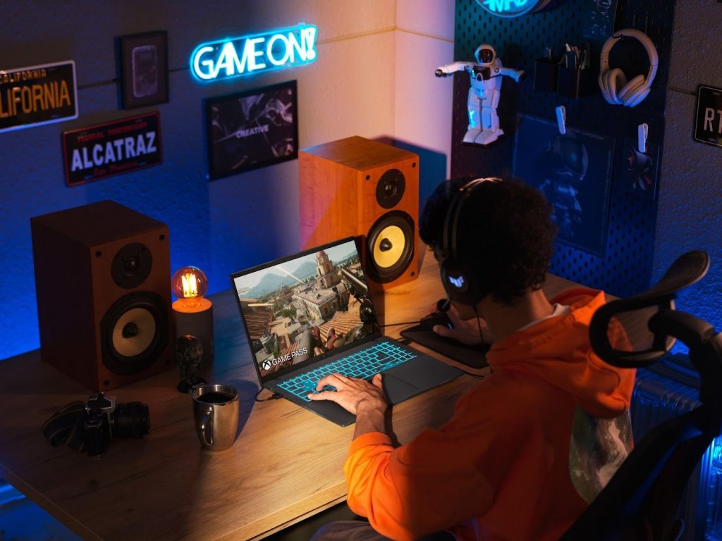 Pessoa jogando em um notebook ASUS V16 em setup gamer iluminado, ilustrando o tema black friday asus.