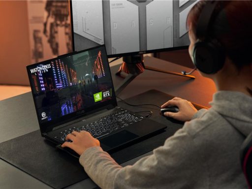 Vista diagonal traseira de uma pessoa jogando Watch Dogs: Legion em um notebook gamer ASUS TUF Gaming, com as mãos posicionadas no teclado e mouse.