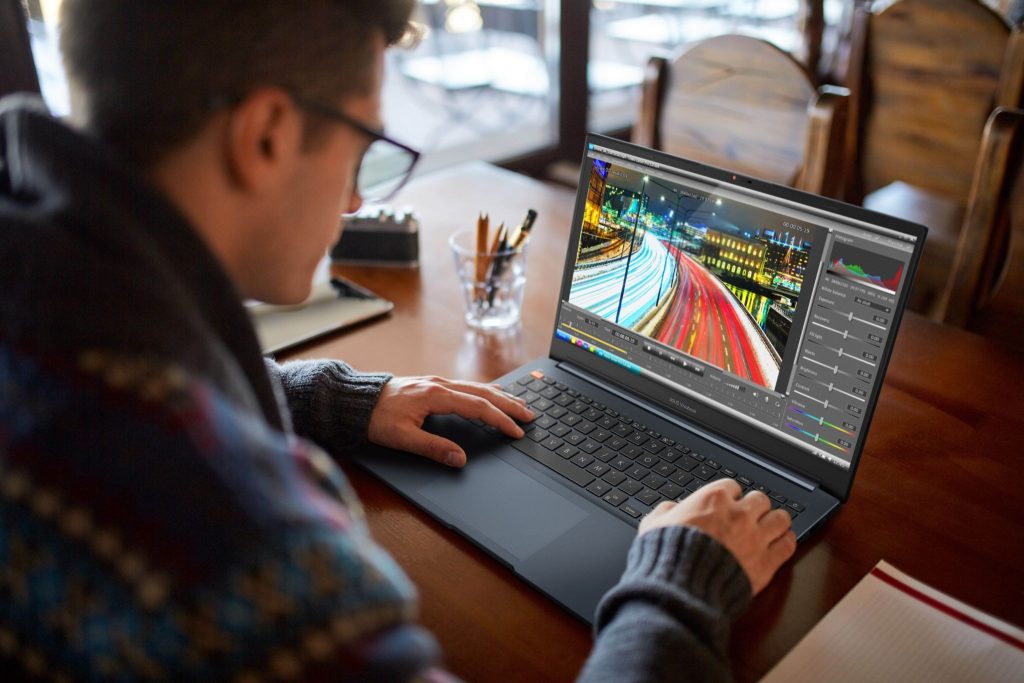 Vivobook Pro 15/16 OLED Homem utiliza notebook Vivobook Pro 15/16 OLED K6502 K6602 para edição de vídeo profissional com software de correção de cor em ambiente interno.
